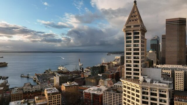 Cinematic 4K aerial drone footage of waterfront Seattle downtown, Elliott Bay, Bainbridge Island Ferry, Pioneer Square, Smith Tower skyline with skyscrapers high-rise offices