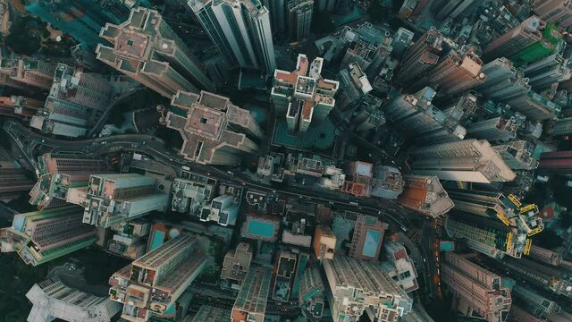 Cinematic drone shot of a city with a lot of skyscrapers during the day. There is many roads with traffics.