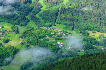 Clouds above a district of the town of Les Houches in the Mont Blanc Massif in Europe, France, the Alps, towards Chamonix, in summer, on a sunny day.