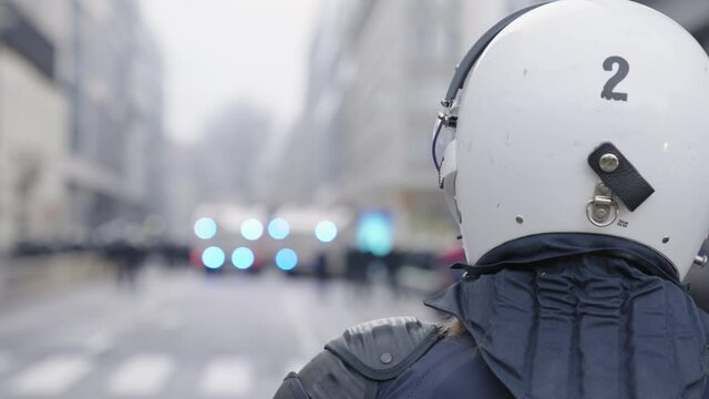 Close up Of Police Officer Wearing White Helmet With Bokeh Lights From Vehicle.