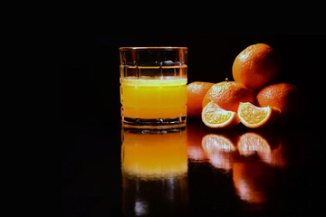 Fototapeta Mandarynki i pomarańcze jako sok. Orzeźwiająca moc owoców w szklance. Świeżość, witaminy, piękno, moda, wegetarianizm. pasja w samo zdrowiu owoców. Zielone życie, namiętne chwile. obraz