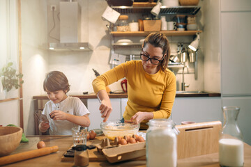 mother and child in kitchen, preparing cookies