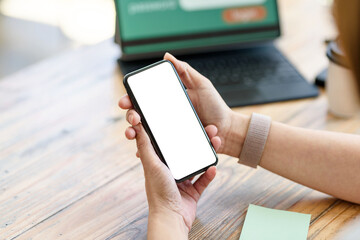 Woman sitting holding a smartphone blank white screen at the office. Mock up
