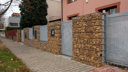 Gabion retaining wall - brown stones in gabion metallic baskets kept by retaining wall. Modern...