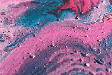 Fluid Art. Embossed strokes and drips of pink and turquoise paint. Marble effect background or texture. Selective focus