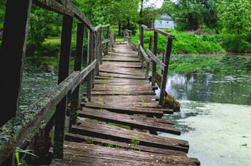 Closeup of  deformed and dilapidated wooden bridge over the canal , Damage wooden bridge decay concept.