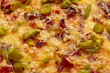 Closeup of jalapeno pieces on top of vegan pizza with soy sausage, mozzarella and tomato sauce