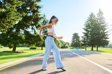Dancing young female teenager on road in park