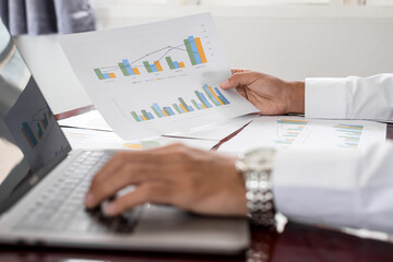 The businessman hand sits at their desks and calculates financial graphs showing the results of their investments planning the process of successful business growth