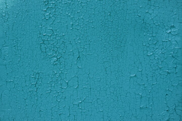old wall close-up. the wall is painted bright blue, cracked by time and the weather. backdrop for photo