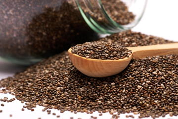 glass can full of organic natural chia seeds close-up isolated on white background