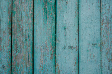 texture of a wooden fence.  fence painted green.  peeling paint on an old fence.  old wood texture.  photo can be used as a photophone, as a texture