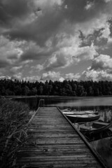 wooden jetty, with boats on the right and a lake in the background