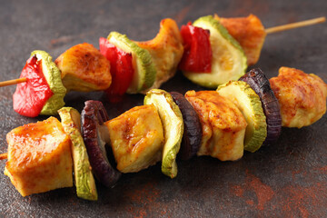 Tasty chicken shashlik on dark textured background