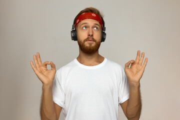 Horizontal studio shot of handsome hipster-looking male in white t-shirt and red bandana wearing...
