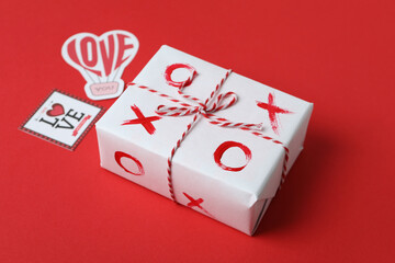 Valentine's Day concept with tic tac toe on gift box on red background