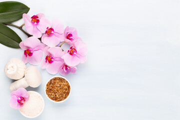 Sea salt, aromatherapy oil in bottles and orchid on vintage wooden background.