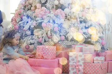 girl with christmas gifts by the tree