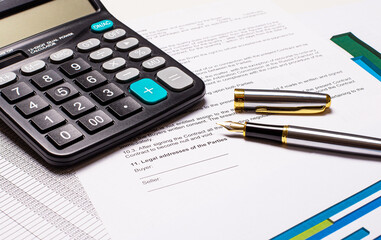 On the desktop, a calculator, documents and a fountain pen. Business concept. Workplace close up