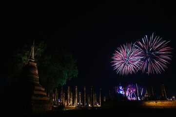 Colorful fireworks near the old principal Buddha image,old pagoda   on the celebration Loy Krathong festival  at the Wat Mahathat Temple in Sukhothai Historical Park. It is a tradition around ancient 