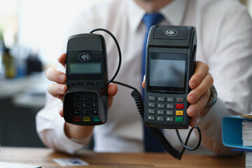 Man hold different models of credit card reader machines for cashless pay