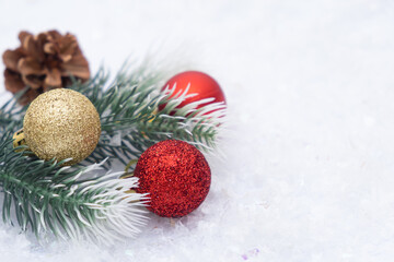 Fototapeta na wymiar Christmas composition of Christmas tree toy red and gold ball snow background tree branch cone