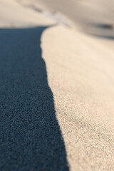 The border between light and shadow at the edge of a sand dune.