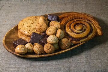 Buns and sweets on a wooden plate