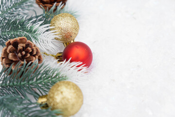 Christmas composition of Christmas tree toy red and gold ball snow background tree branch cone
