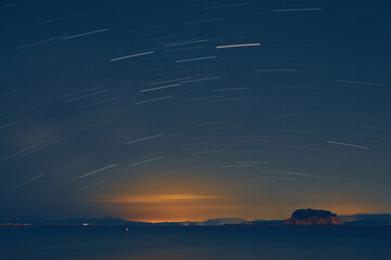 Stars and Milky Way sky with landscape silhouettes.