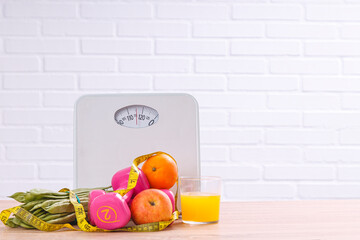 scale, fruits, vegetables, dumbbells and tape measure. diet, nutrition and sport concept