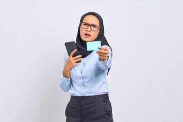 Portrait of surprised young Asian woman holding mobile phone and showing credit card isolated on white background