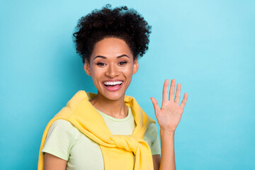 Photo of young cheerful african woman good mood see friends wave hi isolated over blue color background