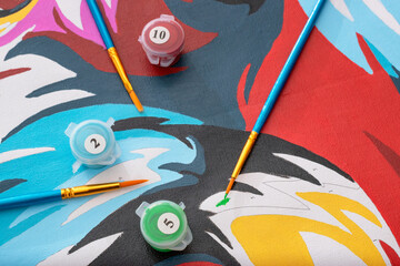Paint by numbers. Canvas painted with numbered brushes and tempera colors. Concept of recreational...