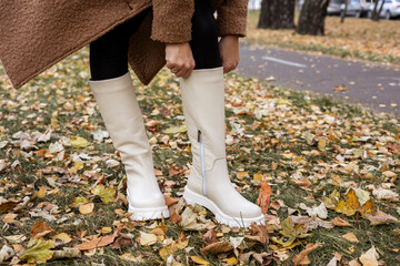 Trendy beige trumpet boots on a female leg, close-up, fashionable. New collection of women's shoes with genuine leather