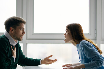 man and woman sitting at the table emotions conflict quarrel