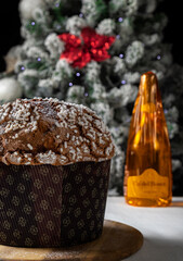Fano - December 14 - 2021 - Panettone -Typical Italian Christmas cake made with eggs, fruit and butter. In the background a bottle of Franciacorta Ca 'del Bosco famous italian sparkling wine.