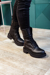 Female legs in black leather boots. New collection of winter boots for women