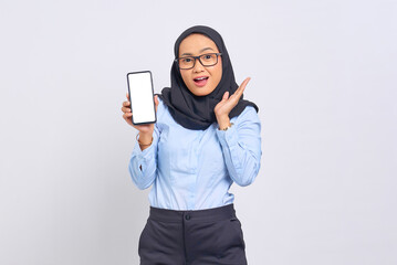 Portrait of surprised young Asian woman showing blank screen mobile phone isolated on white background