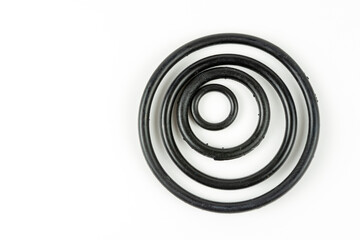 Black hydraulic and pneumatic o-rings in different sizes on a white background. O-rings for...