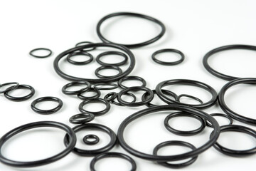 Black hydraulic and pneumatic o-rings in different sizes on a white background. O-rings for hydraulic connections. Rubber seals for sanitary ware.