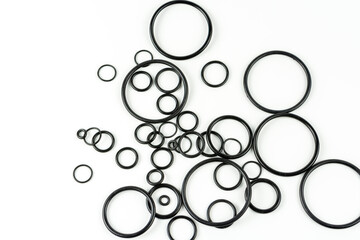 Black hydraulic and pneumatic o-rings in different sizes on a white background. O-rings for hydraulic connections. Rubber seals for sanitary ware. Copy space