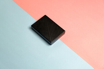 black square powerbank closeup studio photo on pink blue background, two color backgrounds object , studio photo