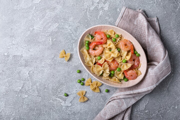 Bowl of italian farfalle pasta with shrimps and green peas