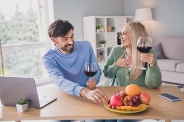 Portrait of two handsome beautiful cheerful people watching video celebrating having fun pastime at home indoors