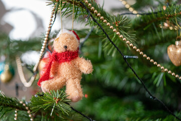 selective focus of a hanging christmas satna bear decoration off a norway spruce tree