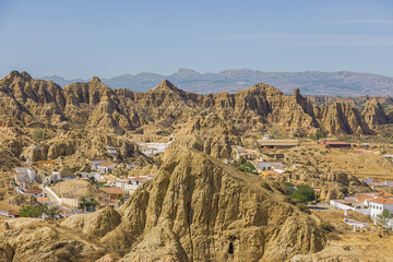 The cave house quarter with troglodyte habitations to protect from the heat in Guadix. The heat causes a blurry view for the distant mountains.