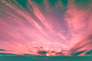 Dramatic colorful cloudy sky at sunset. Gradient pacific pink and green color