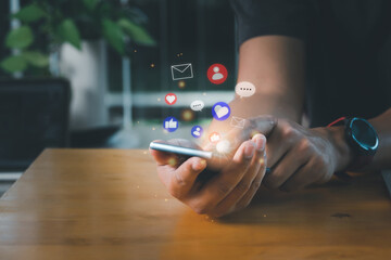 Social media and digital online concept. A man using smart phone for social media with notification icons of contact, love, like, message, and email. Working from home and social distancing concept.