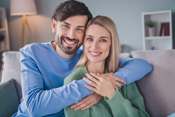 Photo of positive cheerful couple man embrace his sweetheart lady enjoy apartment room free time date relax